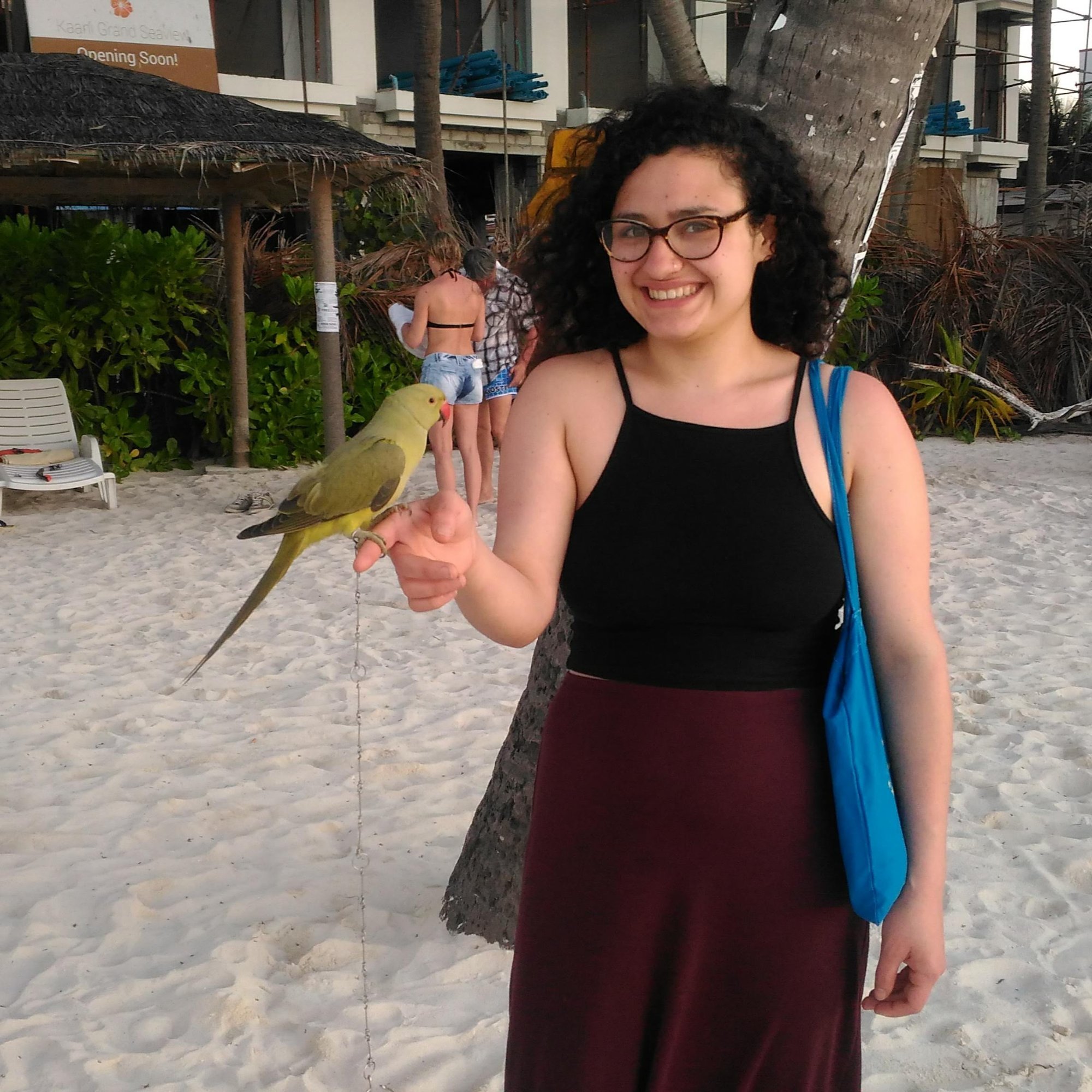Sarah on a beach with a parrot
